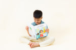 Load image into Gallery viewer, Child reading Korean bilingual children's book titled 'Coco's Lemonade' featuring colorful illustrations of a girl, a dog, and a friend. The title shows text Korean and English.

