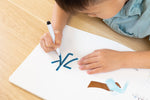 Load image into Gallery viewer, Inside lift‑the‑flap page from the bilingual Mandarin–English children’s book Coco's Lemonade showing a child tracing with dry-erase writeable maker to learn how to write the chinese character, with Mandarin Chinese and English text for early readers.
