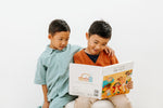 Load image into Gallery viewer, Two boys kids holding the bilingual Korean English children’s book Pay It Forward, showing both the front and back covers with colorful illustrations and Korean–English text.
