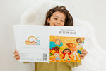 Load image into Gallery viewer, Girl holding the bilingual Mandarin English children’s book Pay It Forward, showing both the front and back covers with colorful illustrations and Mandarin Chinese (Simplified Chinese)–English text.
